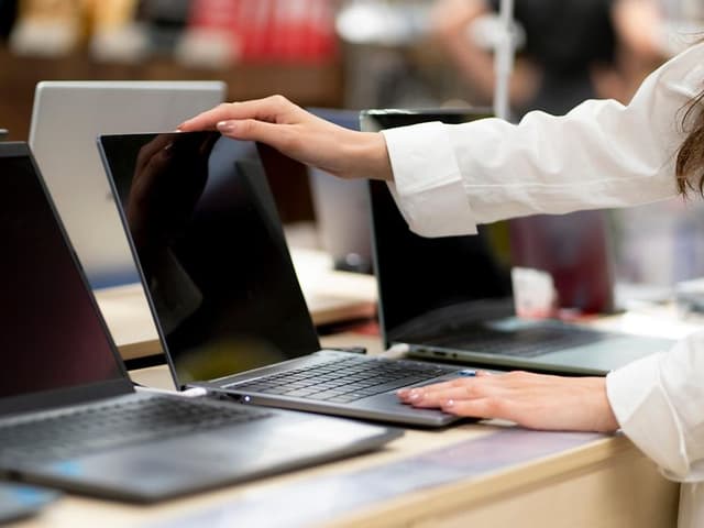 Cheap laptop guide: Woman looking at laptops in a store